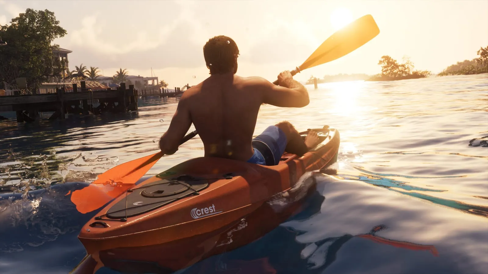 Homme torse nu pagayant un kayak orange au coucher du soleil, une personne allongée à l’avant
